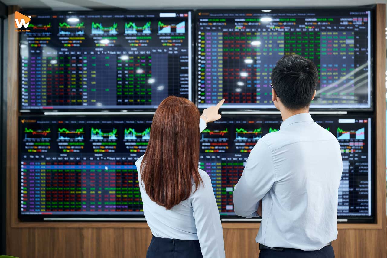 Chuyên viên VFS Securities trước tường màn hình bảng giá chứng khoán